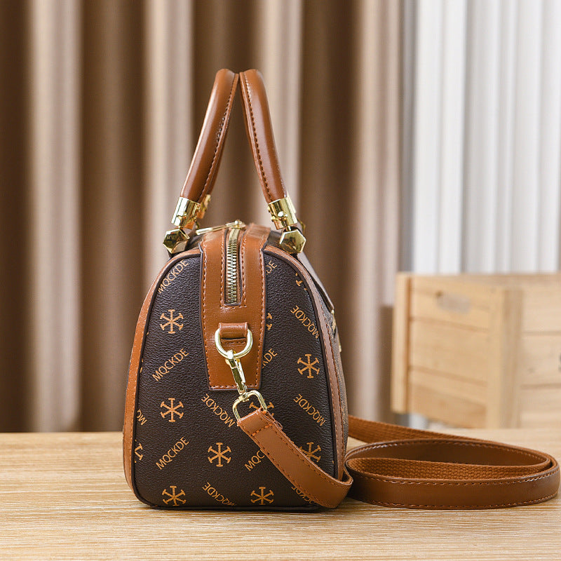 Brown handbag with gold accents on a wooden surface