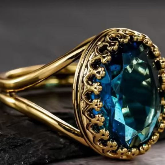Gold ring with a blue gemstone on a dark background