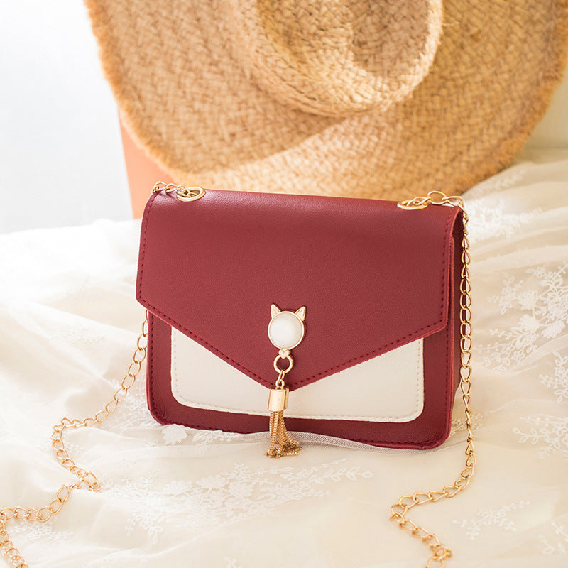 Small square PU leather crossbody bag with flap, tassel chain, wine red and white panels.