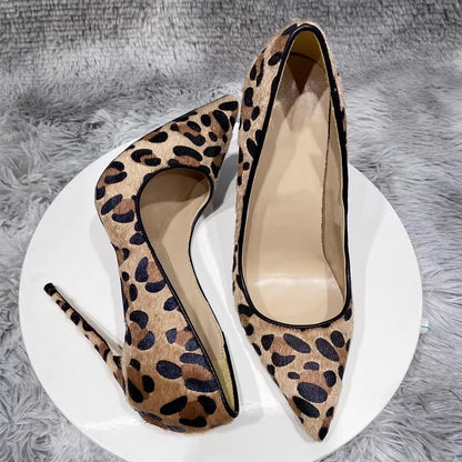 Leopard print high-heeled shoes on a white platform with a gray textured background