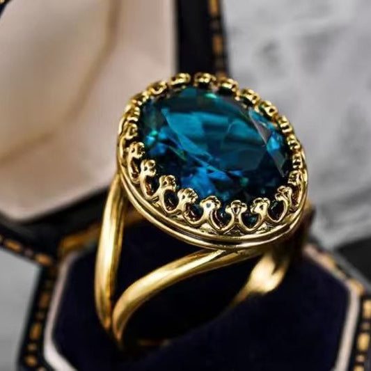 Gold ring with a blue gemstone on a dark background