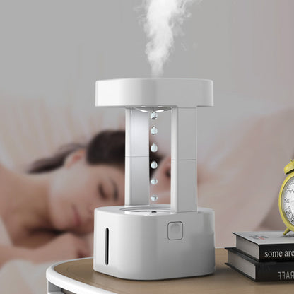 White humidifier on a table with a blurred background of a person sleeping.