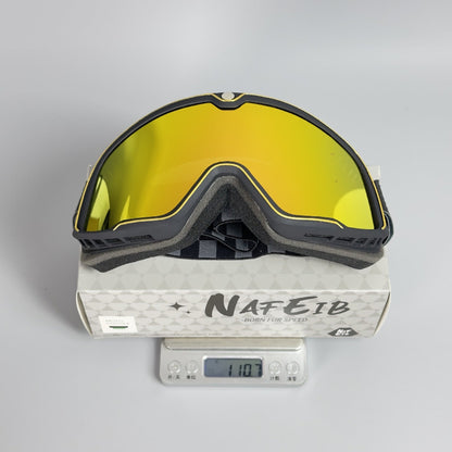 Goggles with yellow lenses on a Nafeib branded box with a digital scale displaying weight.