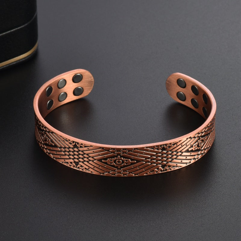 Copper-tone magnetic therapy bracelet, curved patterned band with round magnet inlays.