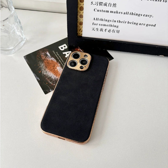 Black phone case with gold camera ring on a white surface