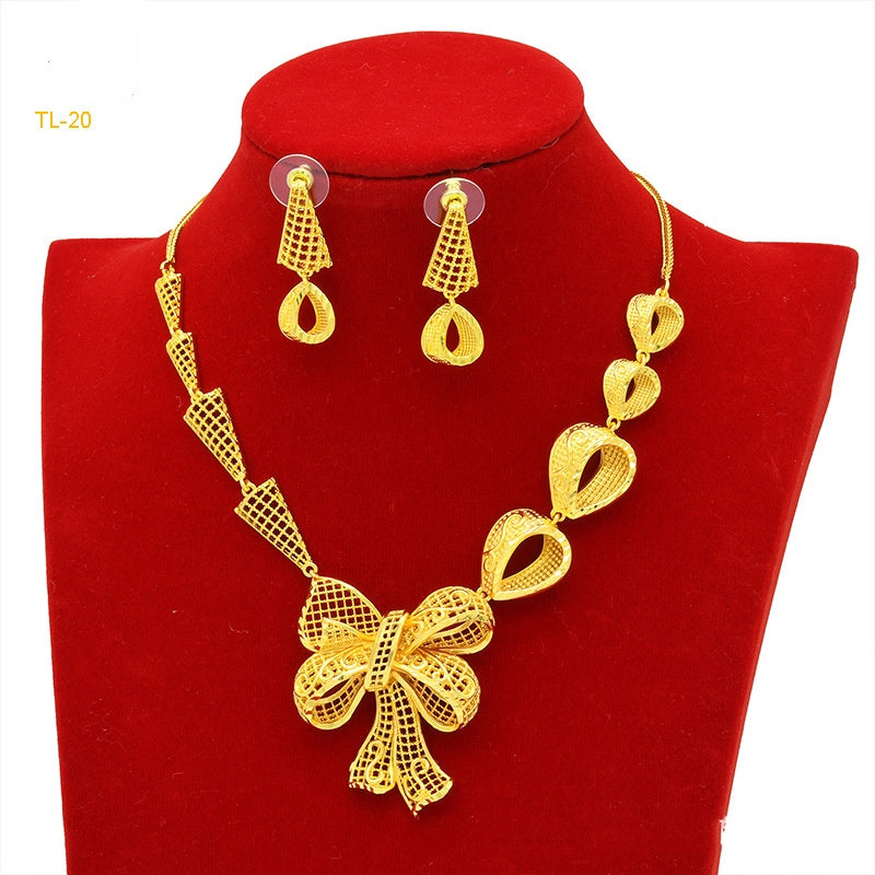 Gold necklace and earrings set on a red velvet stand