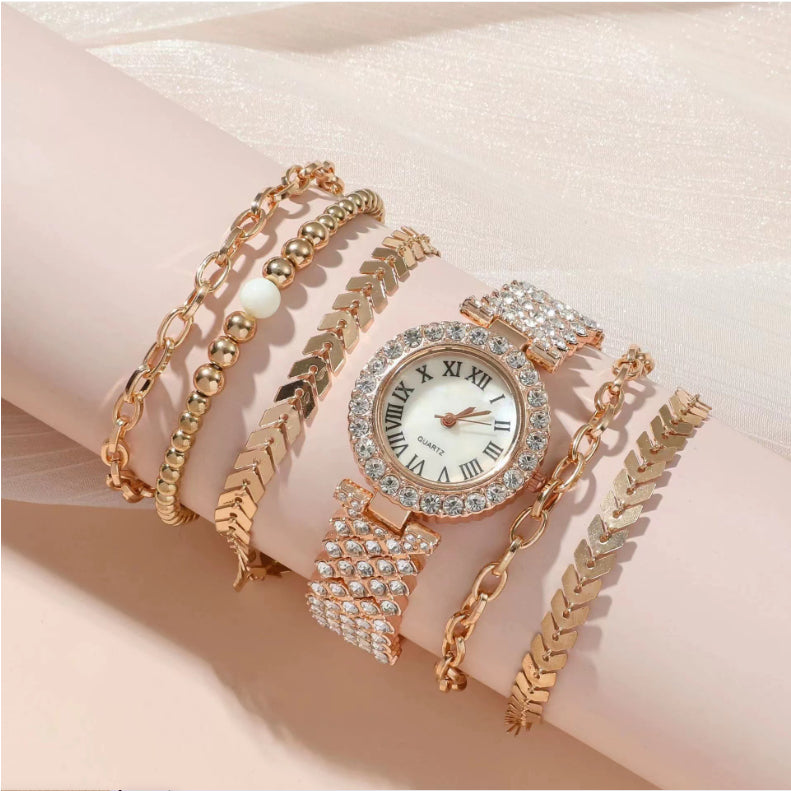 Gold-tone crystal watch with matching bracelet stack, pearl and link details