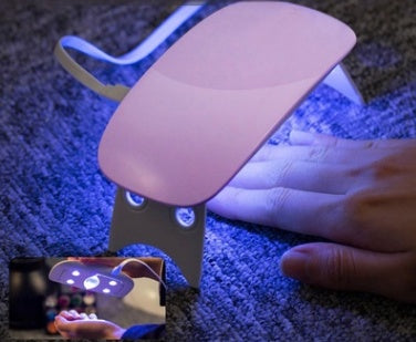 Nail Drayer emitting a blue light on a dark surface