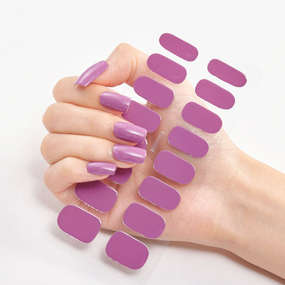 Hand with purple nail polish and additional nail pads on a white background