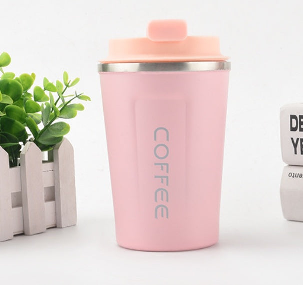 Pink coffee tumbler with a plant and another tumbler in the background