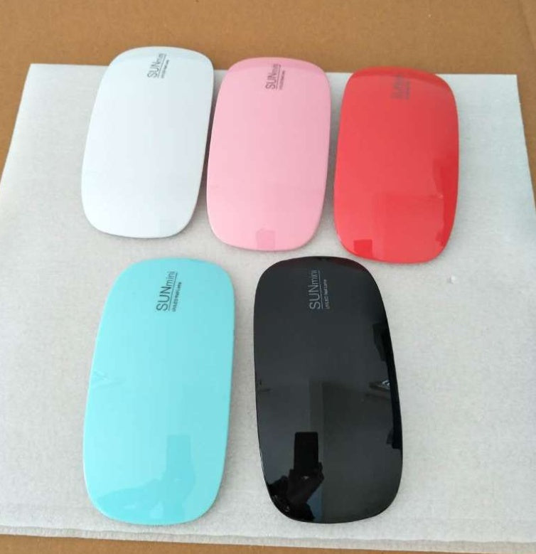 Assorted colors mini portable USB LED nail lamps arranged on a cloth pad