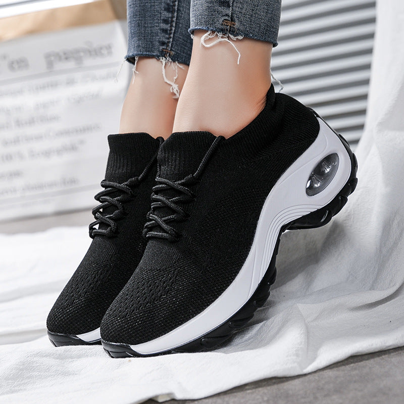 Black knit lace-up athletic shoes with thick white sole and oval air window detail
