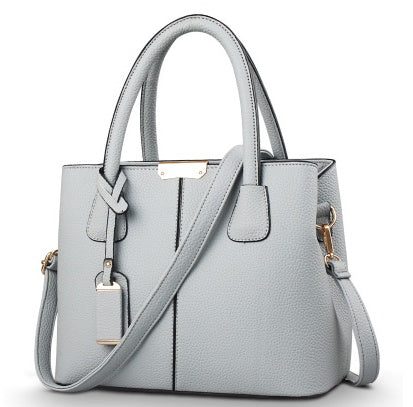 Gray leather shoulder tote bag with structured front panel, top handles, and side straps
