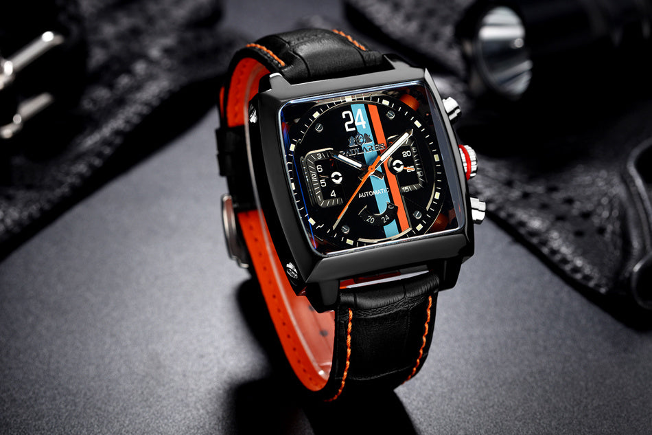 Luxury watch with black and red strap on a dark surface