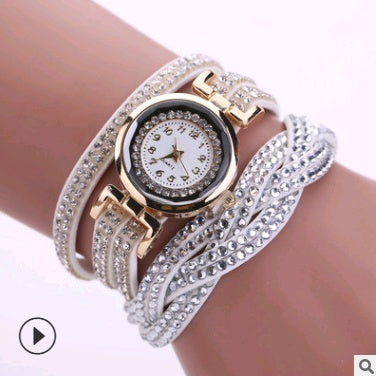 Luxury watch with diamond-studded band on a wrist against a white background