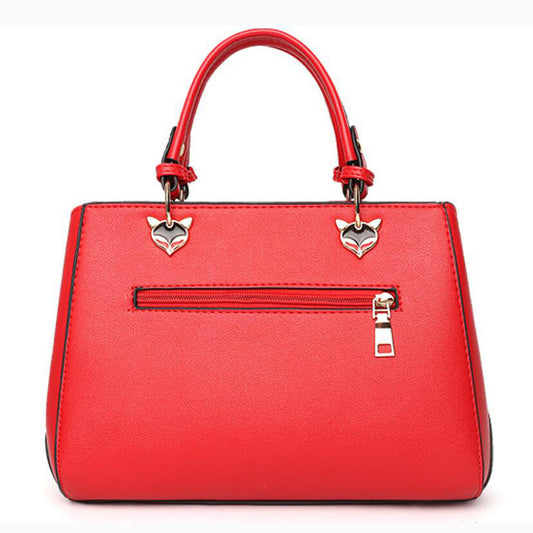 Red handbag with silver heart-shaped charms on a white background