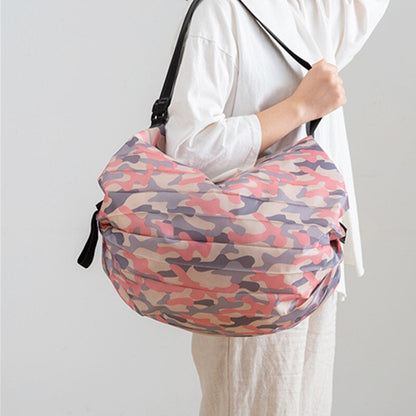 Person holding a pink and purple camouflage bag against a white background
