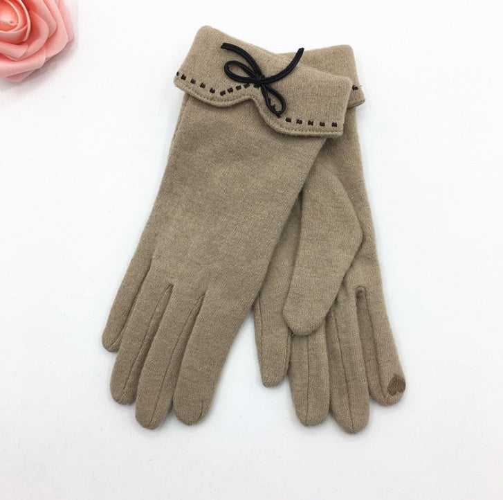 Beige gloves with a decorative bow on a white background