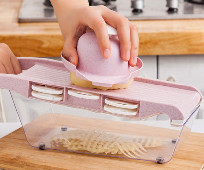 Person using a kitchen tool to slice potatoes on a wooden countertop.