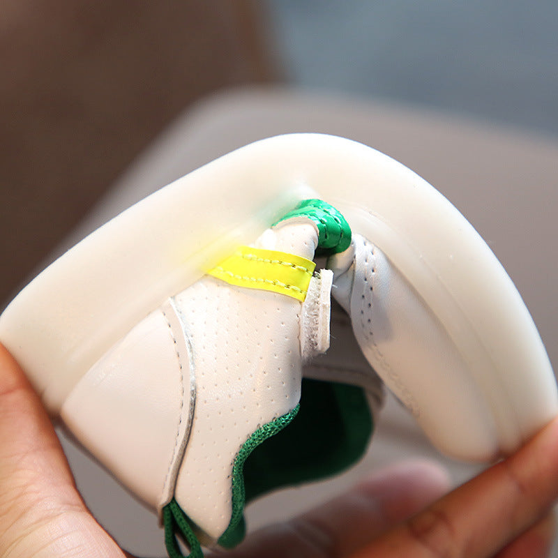 Kids white LED light-up sneaker sole and side strap; green and yellow stripe accents