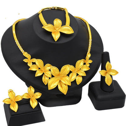 Gold floral jewelry set on a black stand