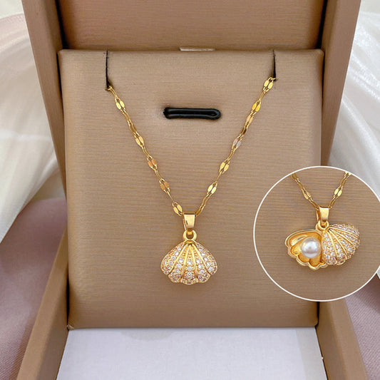 Gold necklace with shell pendant and pearl detail in a box