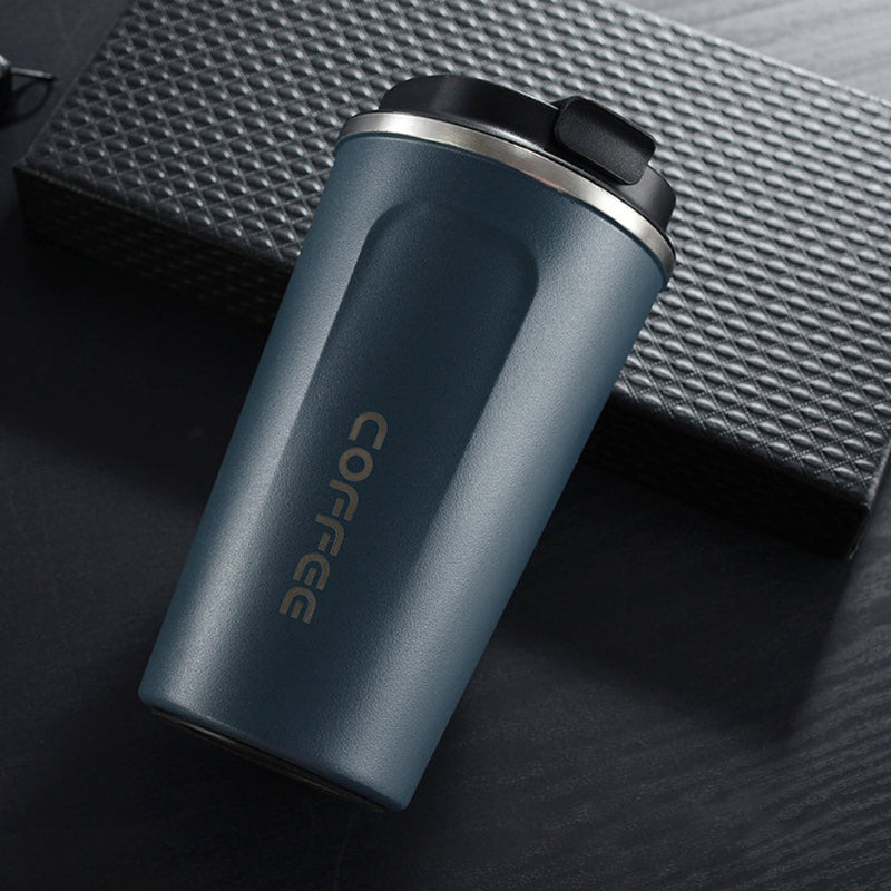 Blue travel mug with 'COFFEE' text on a textured surface