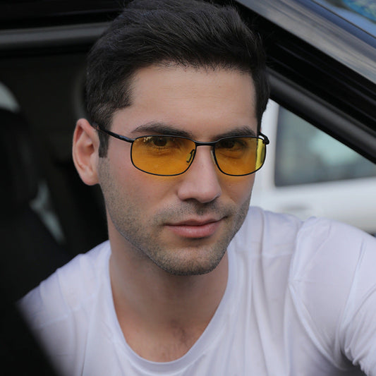 Man wearing yellow-tinted sunglasses inside a car