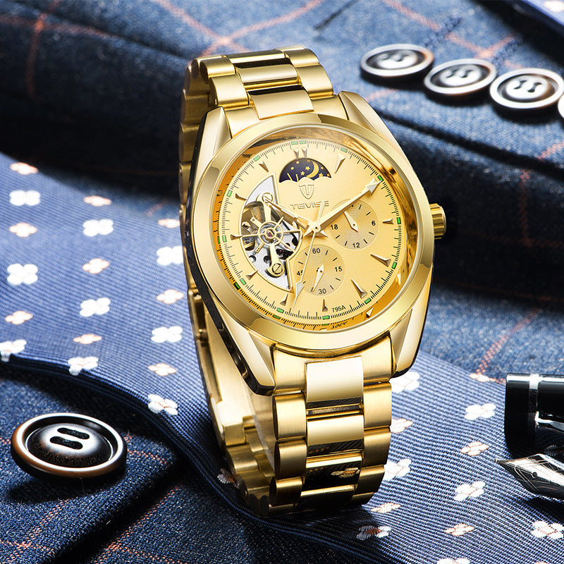 Gold-tone men's mechanical watch with open-heart dial resting on patterned fabric