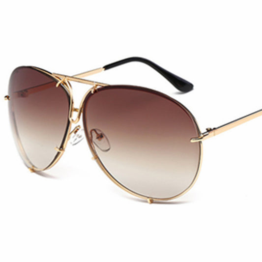 Big-frame unisex sunglasses with dark gradient lenses and gold frame, black temple tips.