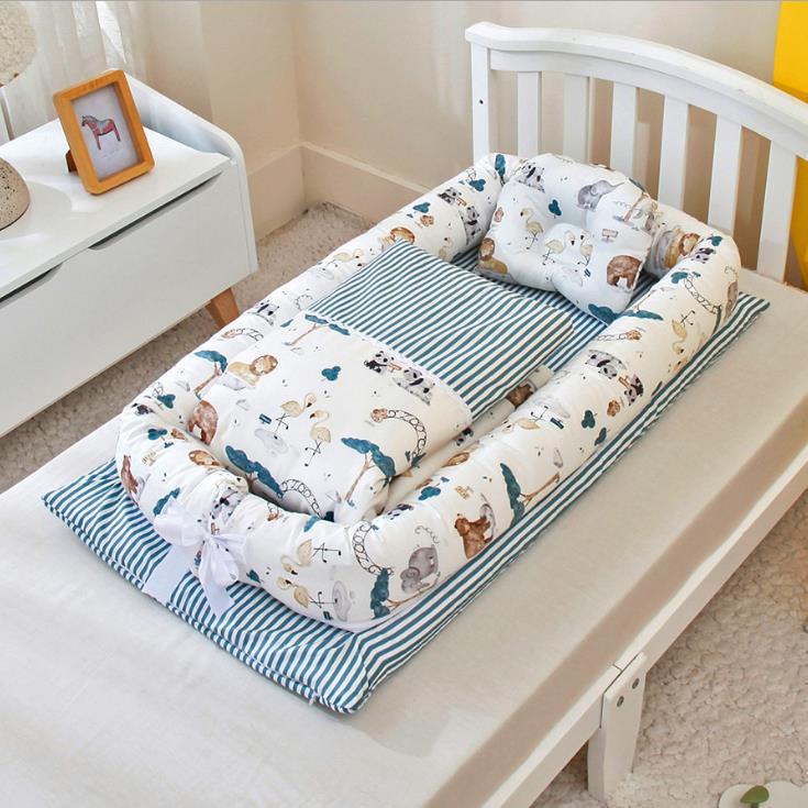 Portable baby nest crib with blue striped animal print mattress and matching pillow