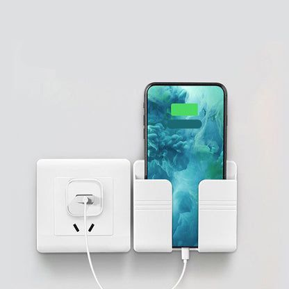 Phone charging station with phone, card holder, and power outlet on a light gray background