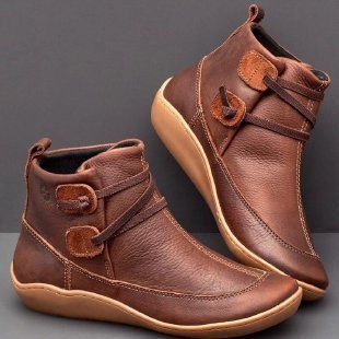 Pair of brown leather ankle boots on a gray background