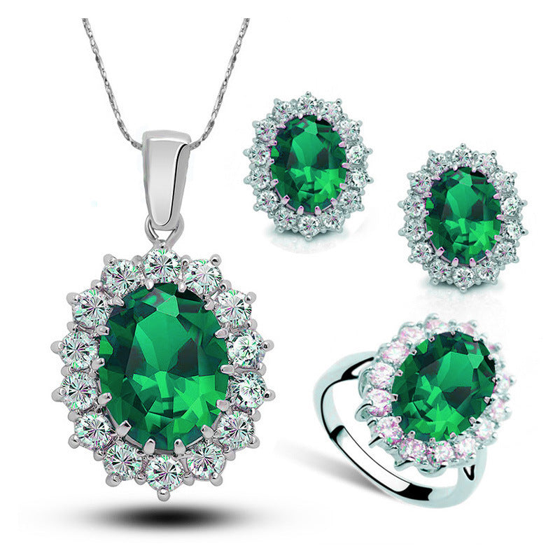 Crystal bridal jewelry set with green gemstone necklace, earrings, and ring in silver tone.