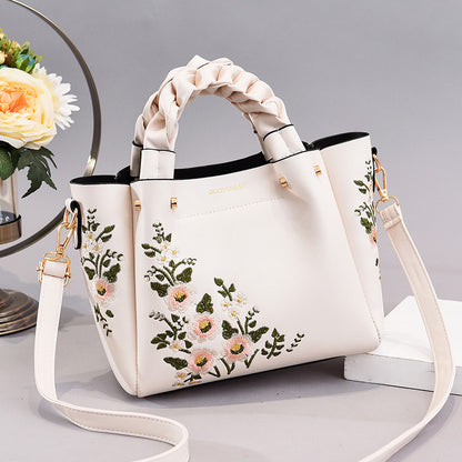 Cream floral PU tote with braided top handles and adjustable crossbody strap