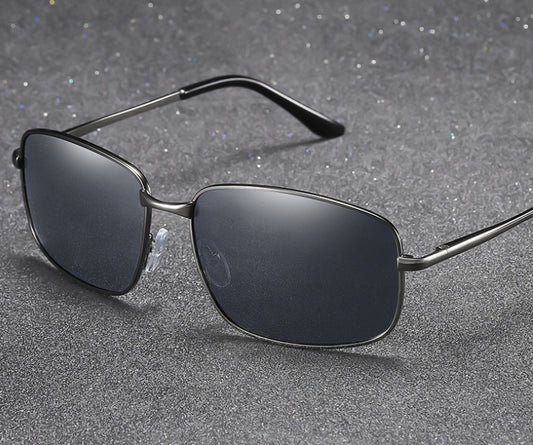 Sunglasses with dark lenses and thin metal frame on a gray textured background