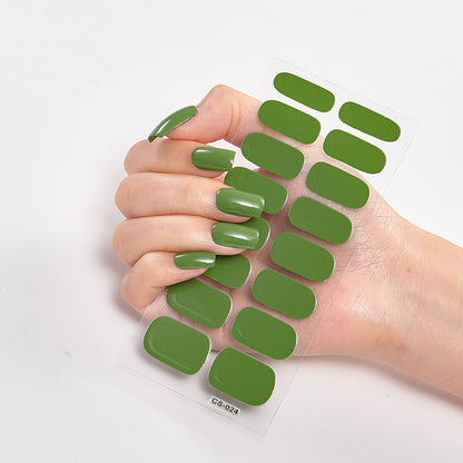 Green nail polish strips on a hand with a white background