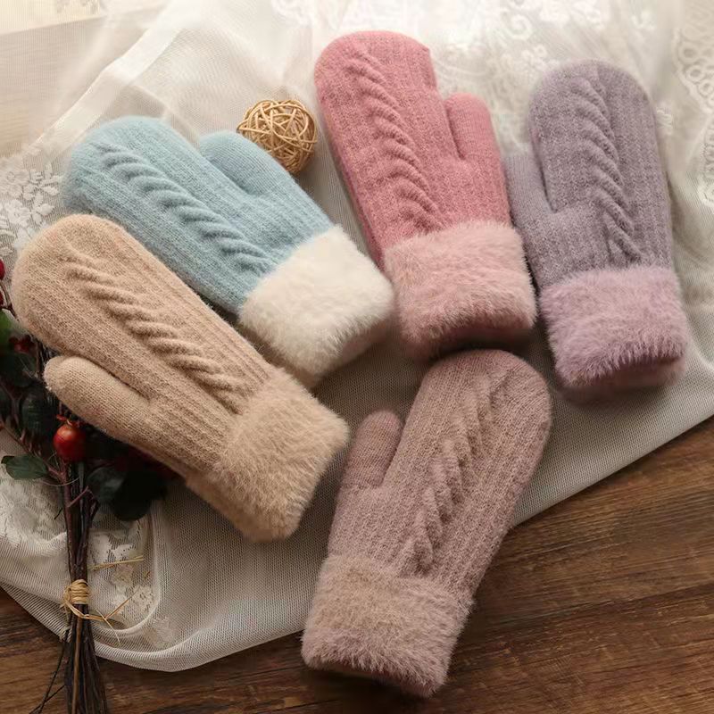 Set of colorful knitted mittens on a textured surface
