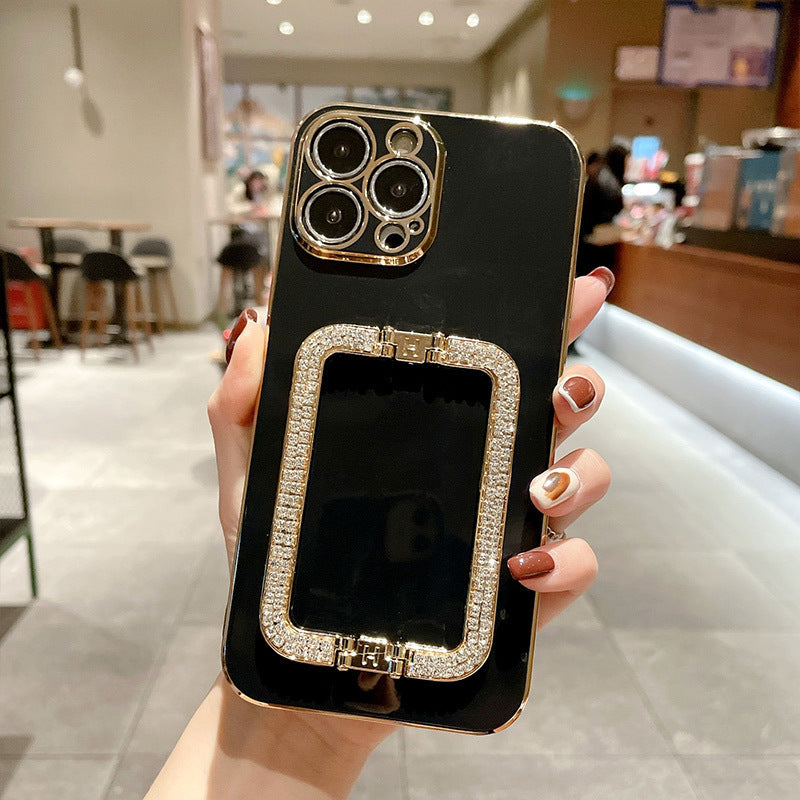 Black phone case with gold accents held by a hand in an indoor setting