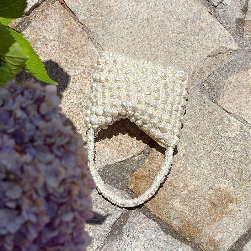 White pearl-beaded woven handbag with curved, scalloped beaded opening and handle