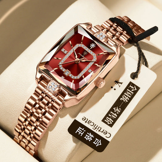 Luxury watch with rose gold strap and red face on a beige background