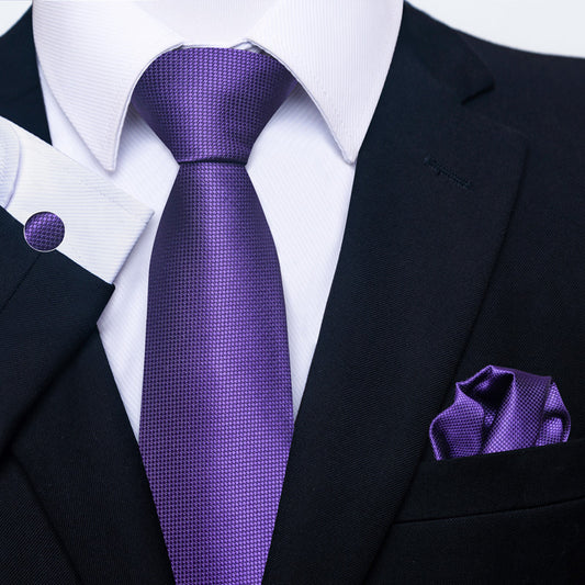 Black suit with a purple tie and pocket square on a white background