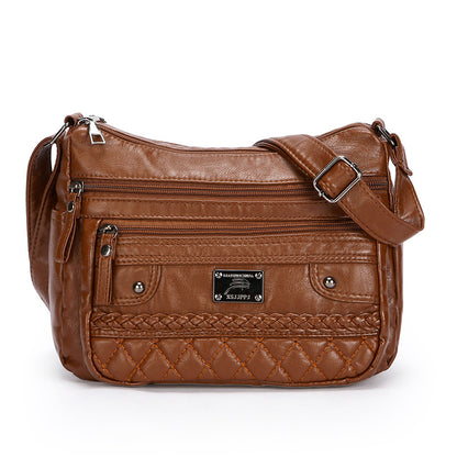 Brown leather handbag with multiple pockets and a brand label on a white background