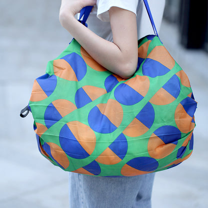 Person holding a colorful patterned bag with blue and orange design