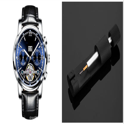 Luxury watch with black leather strap and detailed face, alongside a battery pack on a dark background.