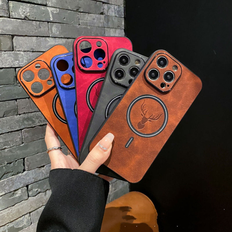 Four phone cases in different colors held by a hand against a stone wall.