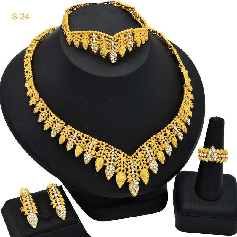 Gold necklace, earrings, and ring set on a black stand
