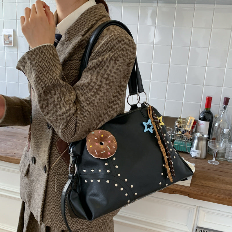 Women's shoulder bag, black with studded trim, donut pendant and star keychain
