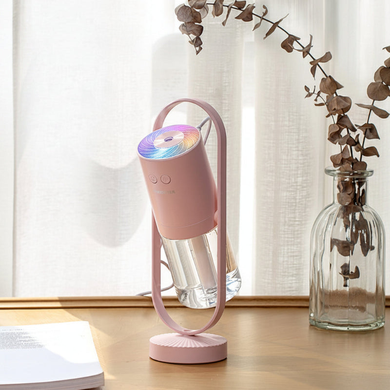 Pink USB ultrasonic humidifier with rainbow LED light ring on stand, mist output