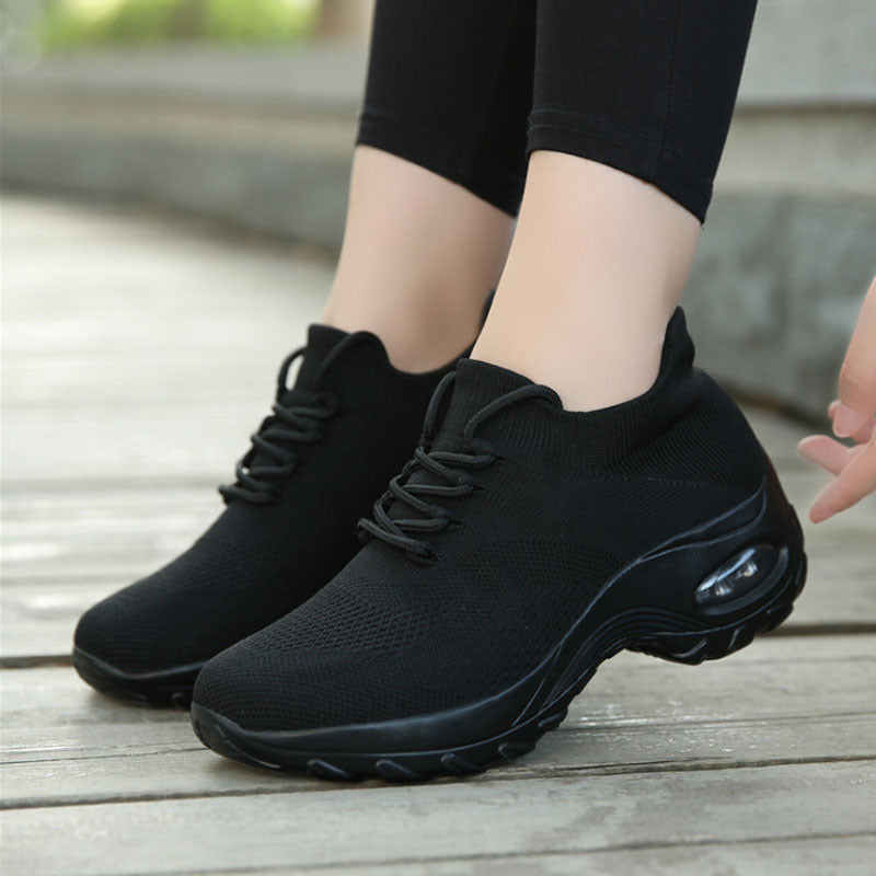 Black knit lace-up athletic shoes with dark sole and oval air window detail